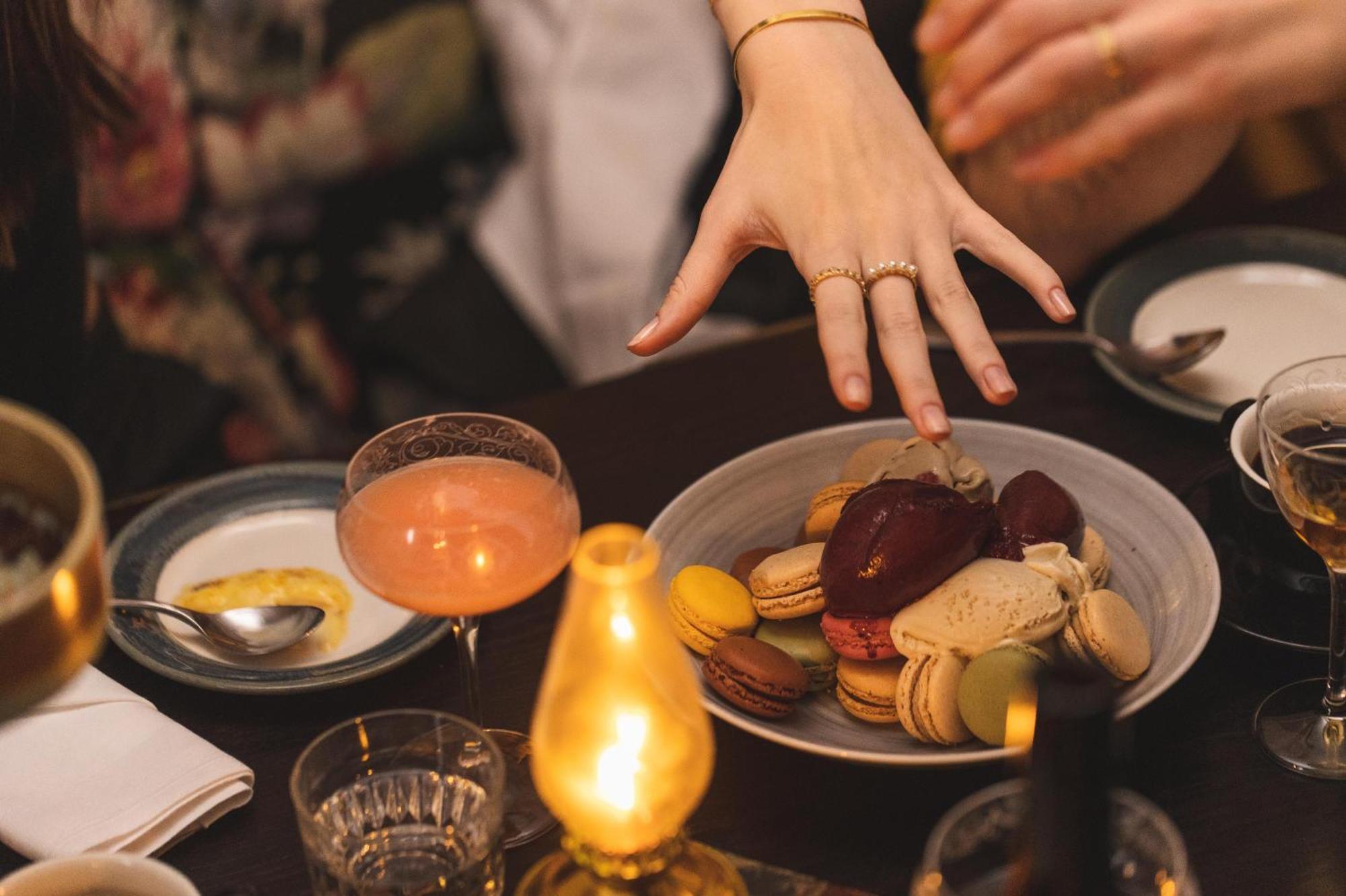 Hotel Pigalle Gothenburg Bagian luar foto A woman's hand reaches for a plate of macarons